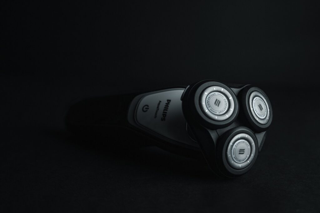 How to clean electric razor heads. Black electric razor with black background.